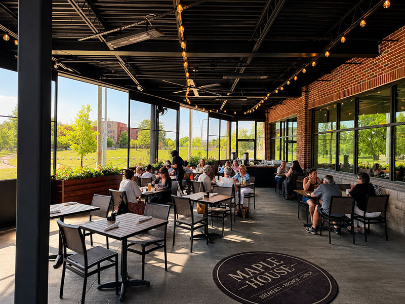 Outdoor terrace dining at Maple House with natural light